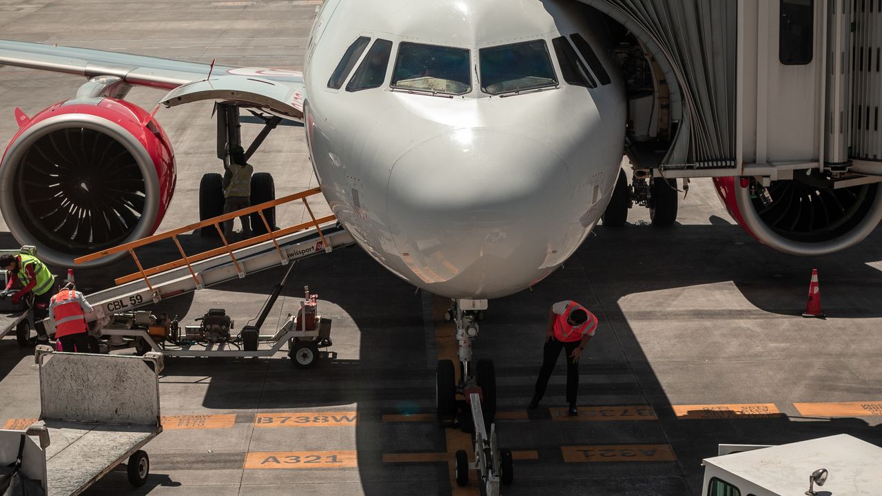 Ground crew working around an aircraft at a stand during a turnaround